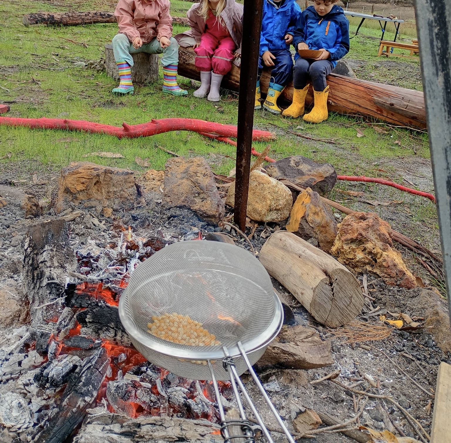 Children gathered around a fire on the property
